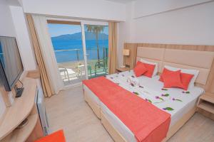 a bedroom with a bed with a view of the ocean at Begonville Beach Hotel - Adult Only in Marmaris