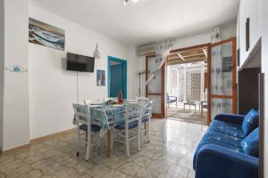 sala de estar con mesa y sofá azul en Blue Apartment by BarbarHouse, en San Cataldo