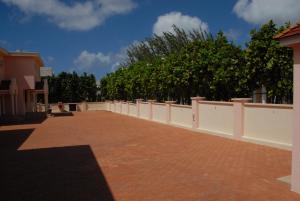 a long white fence with trees in the background at Sandy Bliss Condominiums in Saint James
