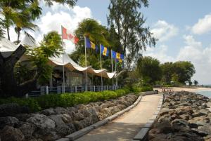 a row of flags in front of a beach at Sandy Bliss Condominiums in Saint James