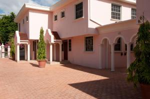 a large white house with a brick driveway at Sandy Bliss Condominiums in Saint James