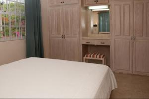 a bedroom with a white bed and a mirror at Sandy Bliss Condominiums in Saint James