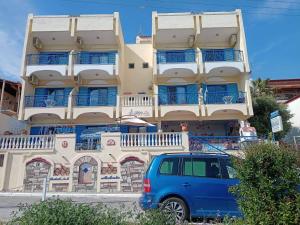 a blue van parked in front of a building at Alexia House in Neos Marmaras