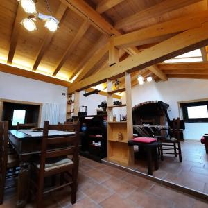 a dining room with wooden ceilings and a table and chairs at La Casa nel Bosco - Your Mountain Holiday in Casargo