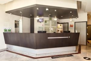 a restaurant with a large counter in a building at B&B HOTEL Saint-Quentin-en-Yvelines Centre Gare 4 étoiles in Montigny-le-Bretonneux