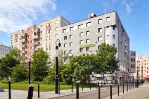 un bâtiment avec un panneau sur son côté dans l'établissement B&B HOTEL Saint-Quentin-en-Yvelines Centre Gare 4 étoiles, à Montigny-le-Bretonneux