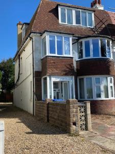 a brick house with a fence in front of it at WORTHING BEACH 180 - 2 bed seafront apartment with private parking in Worthing