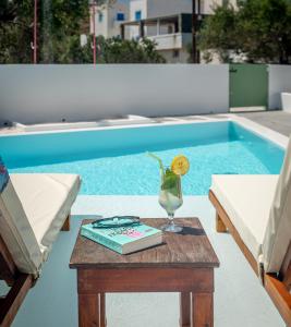 a table with a book and a vase on it next to a pool at Terra Oliva Milos in Pollonia