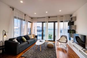 a living room with a couch and a large window at Crystal Holiday Residence in Sukošan