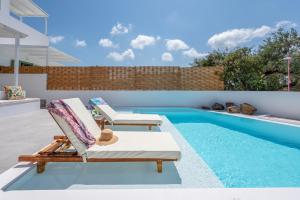 a patio with two lounge chairs and a swimming pool at Terra Oliva Milos in Pollonia