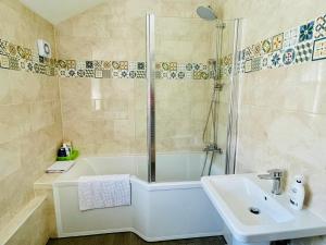 a bathroom with a tub and a sink and a shower at Clive Crest house in Portsmouth