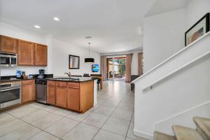 a large kitchen with wooden cabinets and a staircase at Regal Oaks Resort Townhouse in Kissimmee