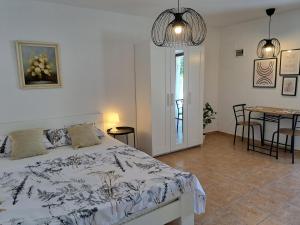 Schlafzimmer mit einem Bett und einem Tisch mit Stühlen in der Unterkunft Apartments Dandić in Orlec