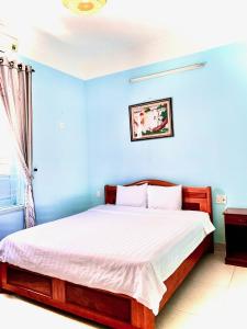 1 dormitorio con 1 cama con pared azul en Areca Homestay en Hoi An