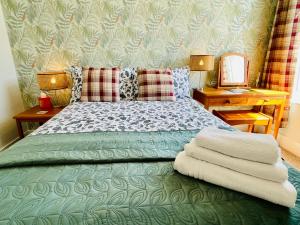 a bedroom with a green bed with two lamps and a mirror at Clive Crest house in Portsmouth