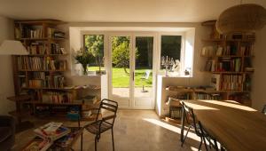 een kamer met een tafel, stoelen en een raam bij Gite Le Rouvre in Cour-Cheverny