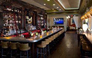 a bar with a long counter and stools at The Pearl Hotel in Rosemary Beach