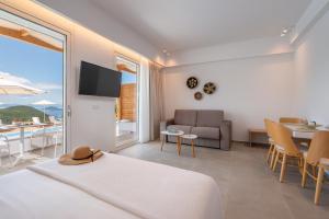 a bedroom with a bed and a couch and a table at Ninemia Luxury Residence in Perdika