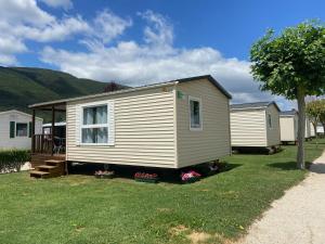 a small white house on a yard with houses at Camping Rio Nela in Trespaderne