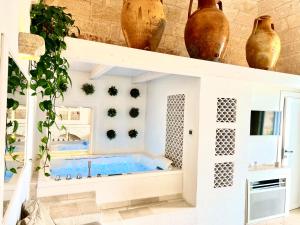 a wellness room with a hot tub and vases at Vittorio Emanuele Charming Suites in Monopoli