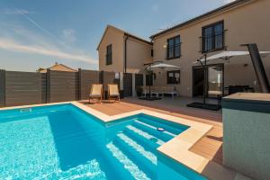 a swimming pool in the backyard of a house at Villa NiA ZadarVillas in Nin