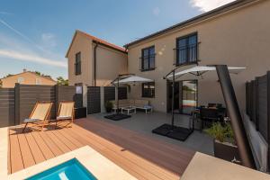 a backyard with a swimming pool and a house at Villa NiA ZadarVillas in Nin