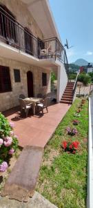 a patio with a table and chairs and flowers at Apartments Radulovic in Sutomore