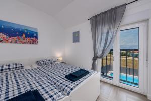 a bedroom with a bed and a large window at Villa NiA ZadarVillas in Nin +50 photos