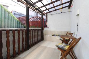 a balcony with a wooden railing and a chair at Apartment Besima 2178 in Pula