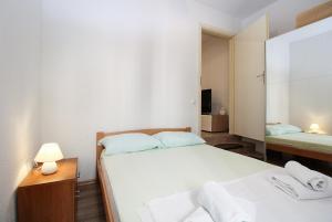 a small bedroom with two beds and a night stand with a lamp at Apartment Besima 2178 in Pula