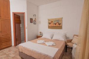 Ligres Beach - 2 Bedrooms Apartment Sea View في Agia Paraskevi: غرفة نوم بسرير وكرسي ودهان
