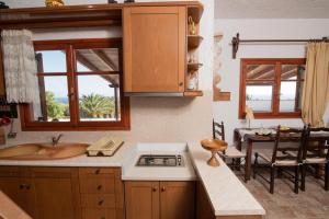 Ligres Beach - 2 Bedrooms Apartment Sea View في Agia Paraskevi: مطبخ مع مغسلة وموقد وطاولة