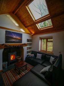 ein Wohnzimmer mit Couch und Kamin in der Unterkunft Beili Glas Cottage in Pontardawe