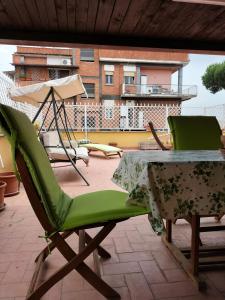 2 sillas verdes y una mesa en el patio en Appartamento Roma Casilina en Tor Vergata