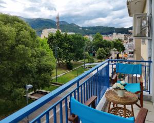 a balcony with blue chairs and a table with a view at Hospitable appartment in the central park, Xanthi in Xanthi