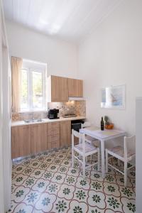 a kitchen with a table and two chairs and a table at Jasmine Home by the Sea in Kalyves