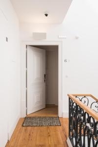 - un couloir avec une porte blanche et du parquet dans l'établissement Madalena Orquidea Living Apartments, à Lisbonne
