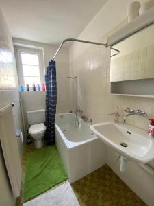 a bathroom with a sink and a tub and a toilet at Heart of Basel, Beautiful Guest House in Basel