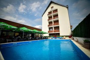 a swimming pool in front of a hotel at Apartments Mons in Vila Katalina in Zlatibor