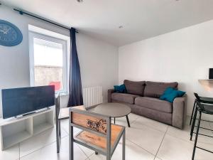 salon z kanapą i telewizorem w obiekcie Chez Ellie-Maison de ville à Concarneau w mieście Concarneau
