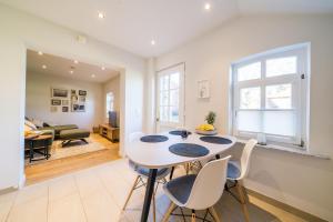 a dining room with a white table and chairs at Leuchtturmhaus 1888 EG Wohnung in Borkum