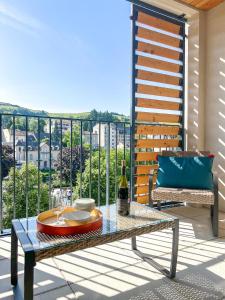 a table on a balcony with a bottle of wine at Le frère Charmes in Aurillac