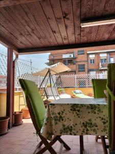 una mesa y sillas en un patio con sombrilla en Appartamento Roma Casilina en Tor Vergata