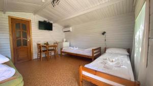 a room with two beds and a table in it at Olle Holiday house in Ventspils