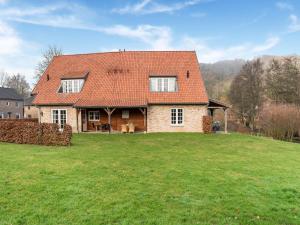 ein Haus mit einem orangenen Dach auf einem grünen Feld in der Unterkunft Residentie Heesdael in Slenaken