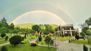 um arco-íris sobre um jardim com um edifício em Royal Palace Hotel, Lagodekhi em Lagodekhi