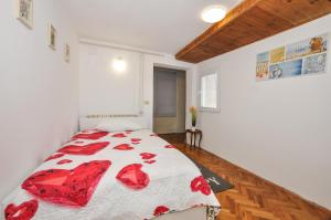 Schlafzimmer mit einem Bett mit einer roten und weißen Bettdecke in der Unterkunft Apartment KATARINA Koper - old historic centre with free parking in Koper