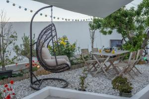 a patio with a swing and a table and chairs at Milos Guesthouse in Triovasálos