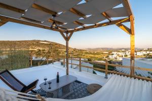Milos Guesthouse في Triovasálos: اطلالة من بلكونة منزل مع طاولة وكراسي