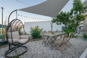 a patio with a table and chairs and an umbrella at Milos Guesthouse in Triovasálos